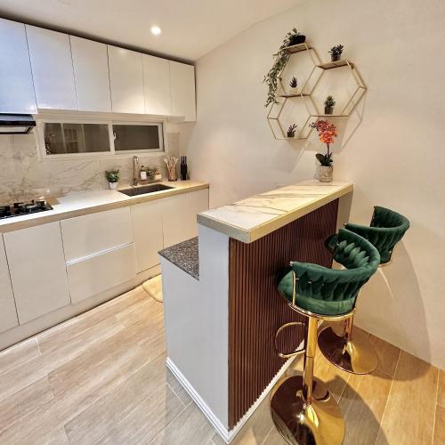 a kitchen with white cabinets and a green bar stool at Annie's Place Puerto Princesa in Puerto Princesa City