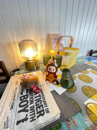 a table with a magazine and a stuffed animal and a lamp at Impact Arena C3 Milo in Nonthaburi