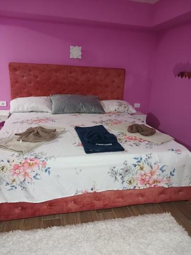a bedroom with a large bed with purple walls at Apartman IN Pančevo in Pančevo