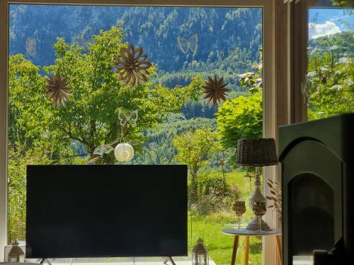 a flat screen tv sitting in front of a window at Countryhouse Lake Attersee - Traumhaft schöne Lage - Bezauberndes Hideaway in Unterach am Attersee