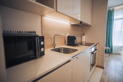 a small kitchen with a sink and a microwave at Beograd na vodi - BW AURORA LUXURY in Belgrade