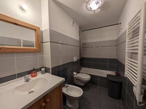 une salle de bain avec un lavabo, des toilettes et un miroir dans l'établissement Appartement montagnard lumineux 8 pers - Terrasse & accès piste - FR-1-445-1, à Montgenèvre