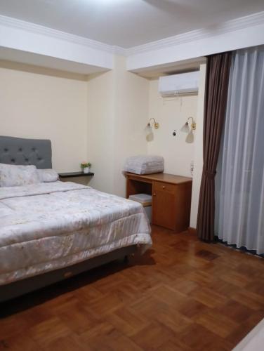 a bedroom with a bed and a dresser and a desk at Resa Living in Mantaak