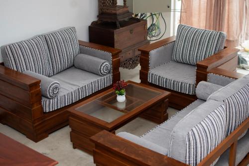 a living room with two couches and a coffee table at Danish Crown Hotel in Ambalangoda
