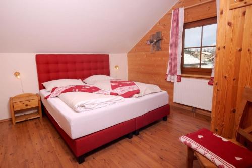 a bed in a room with a red headboard at Skiurlaub und Wanderurlaub am Katschberg Almchalet am Katschberg by FeWo-Planlan in Katschberghöhe