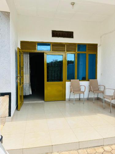 an empty room with a yellow door and chairs at Quiet Gem in Kigali