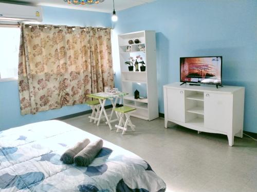 a bedroom with a bed and a tv and a table at Lively Impact C3-C9 in Nonthaburi