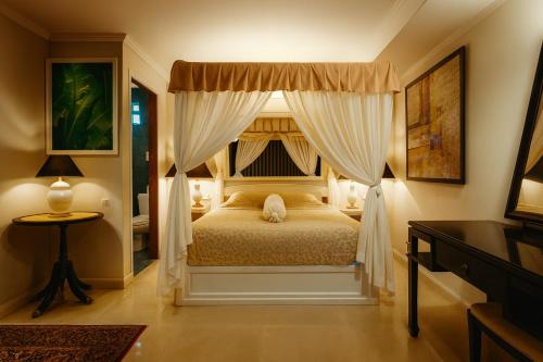 a bedroom with a canopy bed with curtains at Orchid Hotel and Spa Kalim Bay in Patong Beach