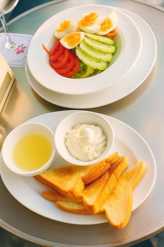 two plates of food with eggs and chips on a table at Orchid Hotel and Spa Kalim Bay in Patong Beach