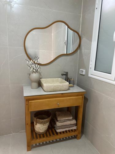 a bathroom with a sink and a mirror at Deux Villa hessi jerbi zarzis in Zarzis