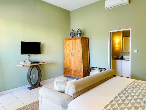 スミニャックにあるRoom Sweet Room - Seminyak Center, walk to the Beachのベッドとソファとテレビのある寝室