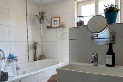 a bathroom with a sink with a mirror and a tub at Charmante 120qm Dachgeschoß-Wohnung in Lippstadt