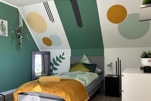 a bedroom with a bed with a green and white wall at Charmante 120qm Dachgeschoß-Wohnung in Lippstadt