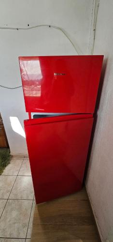 a red refrigerator sitting next to a wall at Selena Rooms in Agia Galini