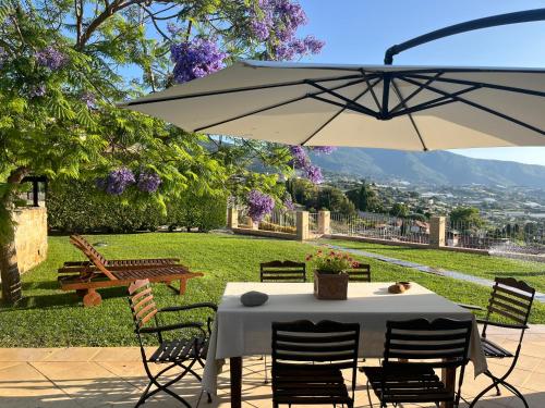 a table and chairs under a white umbrella at La Casa di Pucci Sanremo in Sanremo