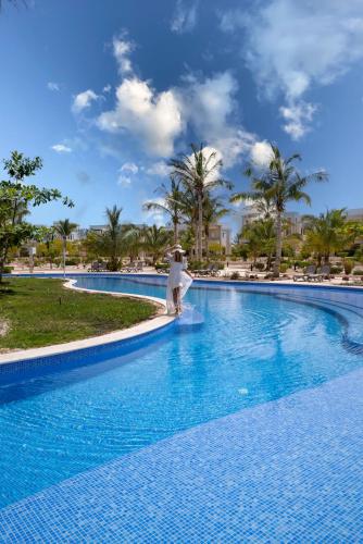 a person standing in a pool at a resort at Juweira Boutique Hotel Adult only in Salalah