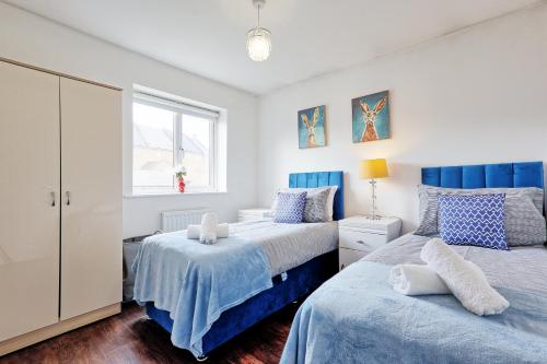 a bedroom with two beds and a window at Modern 3-Bed 3-Bath Home - Quiet Road - Parking For 2 Cars - LMV Property in Great Burstead