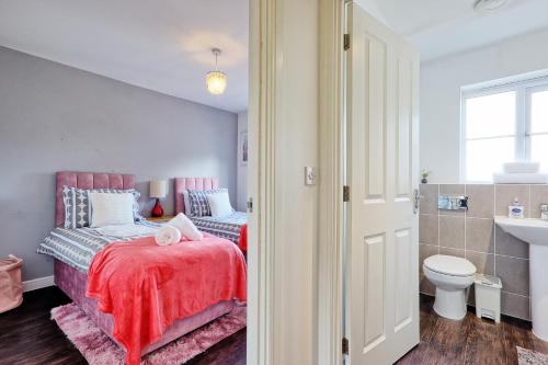 a bedroom with a bed and a toilet and a sink at Modern 3-Bed 3-Bath Home - Quiet Road - Parking For 2 Cars - LMV Property in Great Burstead