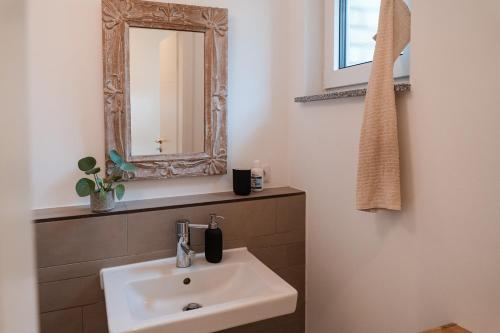 a bathroom with a sink and a mirror at Stilvolles Ambiente im grünen Hamburg! in Hamburg