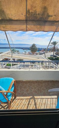 a balcony with a chair and tables on a boat at Selena Rooms in Agia Galini
