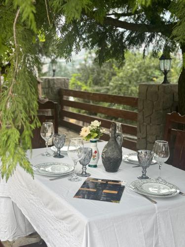 a table with a white table cloth and wine glasses at EleGaya Guest house in Ijevan