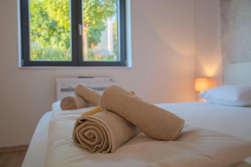 a pile of towels sitting on top of a bed at Summer Breeze in Gornji Humac