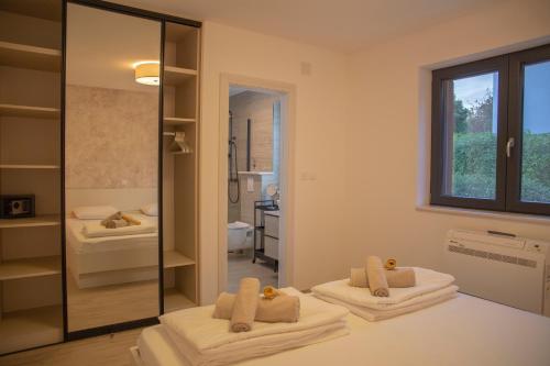 a bathroom with two beds and a mirror at Summer Breeze in Gornji Humac