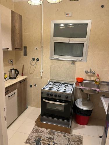 a small kitchen with a stove and a sink at Paradise Gates Madinaty B6 -H- in Madinaty