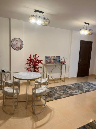 a dining room with a table and chairs and two lights at Paradise Gates Madinaty B6 -H- in Madinaty