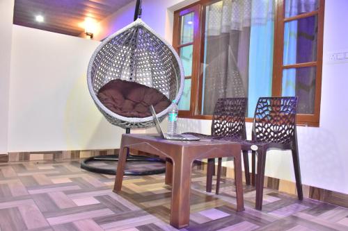 a room with a table and a chair and a hanging basket at The Moonlight Stay Kasauli in Kasauli