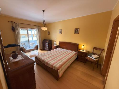 a bedroom with a bed and a table and a chair at Cozy and Quiet Apartment near the Center in Braga