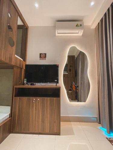 a living room with a tv and a mirror at Chi's House Cao Bang in Hoàng Ngà