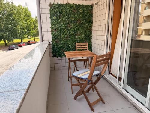 a table and two chairs on a balcony at Cozy and Quiet Apartment near the Center in Braga