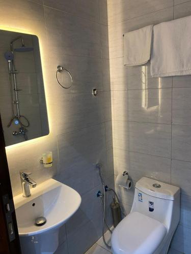 a bathroom with a white toilet and a sink at رامة المدينة للشقق المخدومة in Sīdī Ḩamzah