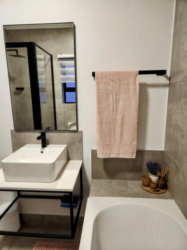 a bathroom with a sink and a tub and a mirror at Urban Contempo Lush in Fourways
