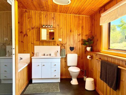 a wooden bathroom with a toilet and a sink at Briar Cottage Weldborough in Weldborough