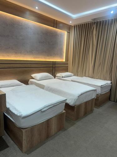 a room with three beds in it with at رامة المدينة للشقق المخدومة in Sīdī Ḩamzah