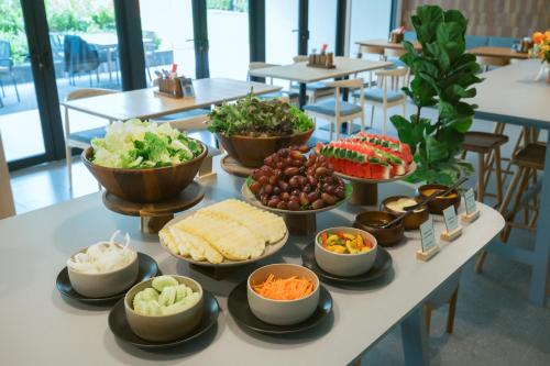 a buffet of food on a table with bowls of food at PAAK Hotel Suvarnabhumi in Lat Krabang