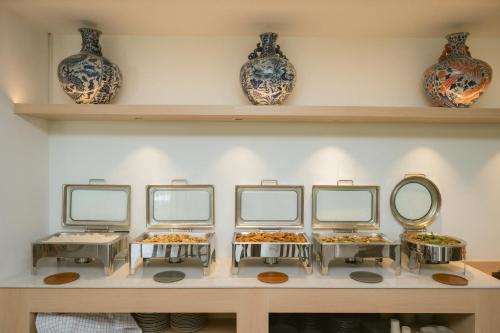 a row of mirrors on a shelf with vases at PAAK Hotel Suvarnabhumi in Lat Krabang