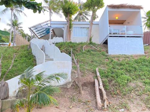 a house on a hill with stairs and trees at Sea for Rest beach club 