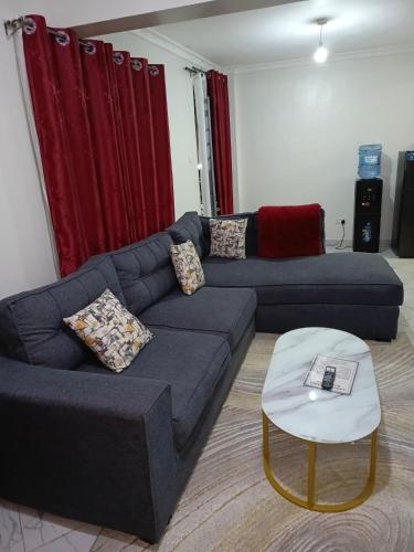 a living room with a blue couch and a table at ELDI Homes in Thika