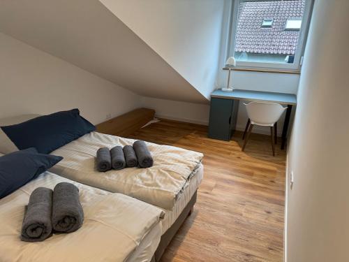 een slaapkamer met twee bedden, een bureau en een raam bij Nagoldblick 4 OG in Pforzheim