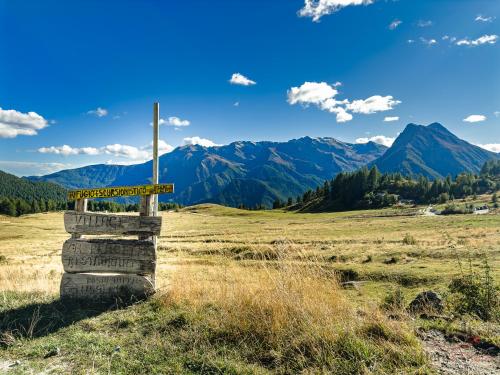 a sign in a field with mountains in the background at Pista Olimpica 1min - Ski Box - Seggiovia 3min in Plan