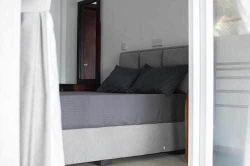 a bed with blue pillows is seen through a doorway at Danish Crown Hotel in Ambalangoda