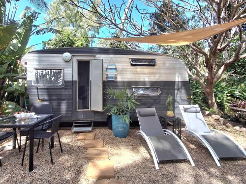 a caravan with a table and chairs and a tent at Vintage Coral Blue in Nelly Bay