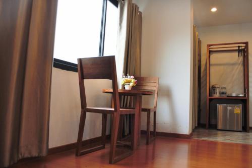 a table and two chairs in a room with a window at Double DD House at MRT Sutthisarn in Bangkok