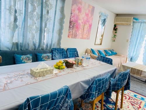 a dining room with a table and blue chairs at 菜音天然温泉別荘 in Tsu