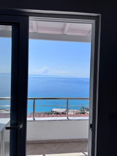 a view of the ocean through a sliding glass door at Sevilia Rooms in Qeparo