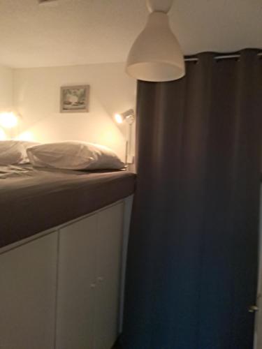 a bedroom with a bed and a blue curtain at Appartement T2 Palavas les flots bord de Mer in Palavas-les-Flots