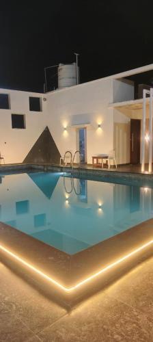 a large swimming pool at night at LALITHA enclove in Tirupporūr